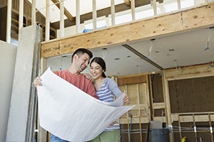 Man and woman looking at building plans standing in their extension. Sandy Spring Bank.