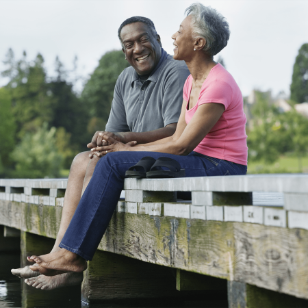 Couple sitting on a fence. Sandy Spring Trust.